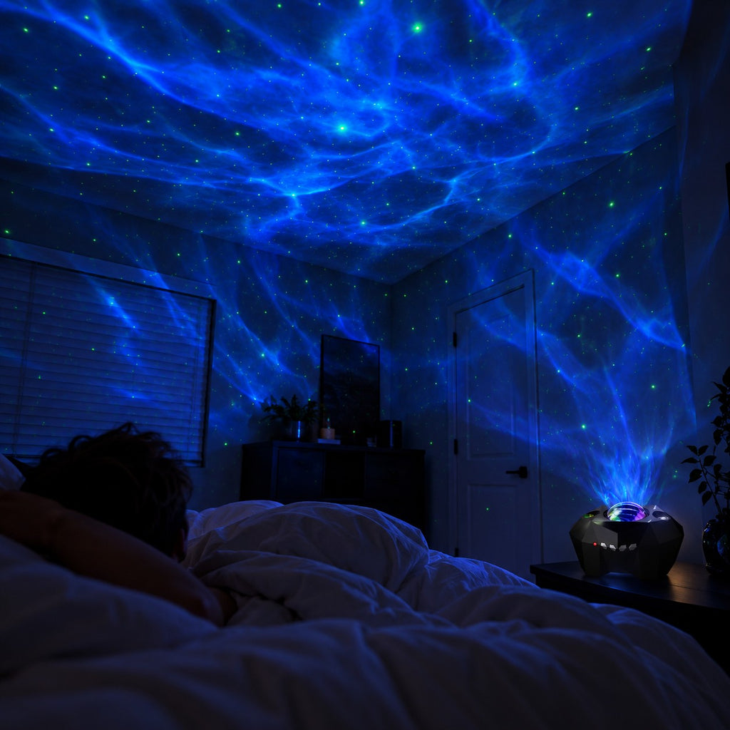 Ocean waves and stars projected across a dark bedroom