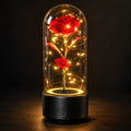 Red rose lamp on a black base, glowing